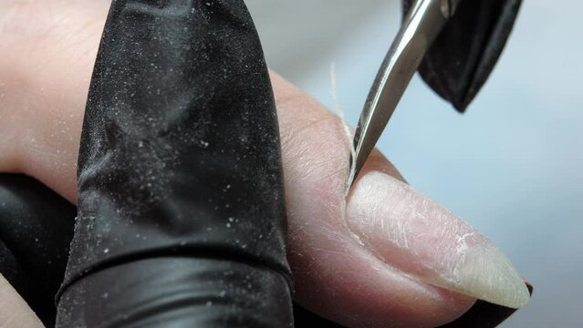 Pruning at the nail cuticle with manicure scissors. Hardware combined manicure.