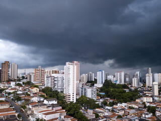 Dramatic drone aerial view of summer rain clouds in Pompeia neighborhood buildings and houses in...