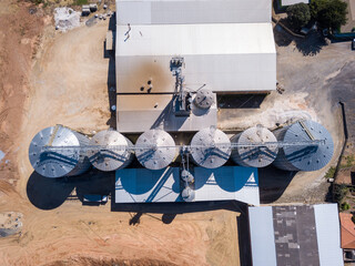 Beautiful drone aerial view of agricultural silos to store soy and corn on farm in Brazil. Concept of agriculture, economy, rural landscape, technology, business. Metal roofs o sunny summer day. © Imago Photo