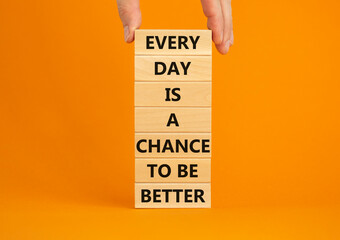 Chance to be better symbol. Wooden blocks with words Every day is a chance to be better. Beautiful orange background, copy space. Businessman hand. Business, motivational chance to be better concept.