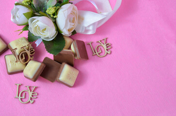 Decorative flowers, chocolate on a pink background. Valentine's Day.