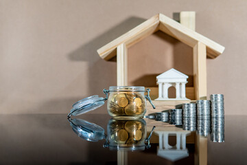 Banking concept. Loan interest rate growth. Saving money for property or real estate investment. Home mortgage and lease. Coin jar and stacked with bank and house model on table.