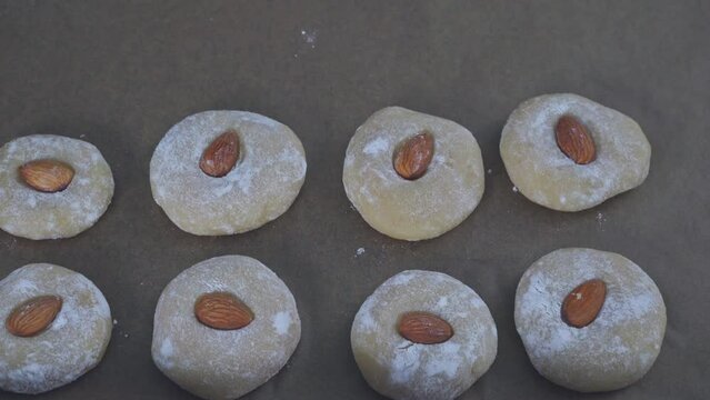 Raw cookies appear on the baking sheet. Stop motion. The process of making gluten-free almond flour cookies. Step by step. Make cookies and place on a baking sheet. Biscotti di mandorla siciliani.