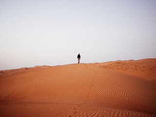 Silhouette marchant sur une dune de sable dans le désert d'Oman