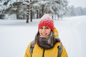 Fototapeta na wymiar Portrait of a cute smiling girl in the snow. Steam from the mouth. Snowy forest and rocks. Climbing the mountain in winter. Survival in the wild.