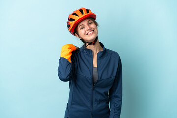 Young cyclist woman isolated on blue background laughing - obrazy, fototapety, plakaty