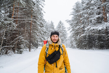 Fototapeta na wymiar portrait of traveler with belt bag and bright backpack. Winter equipment.Snowy forest and rocks. Climbing the mountain in winter. Survival in the wild.