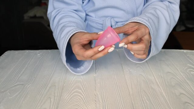 woman show instruction three options versions methods for folding menstrual cup. latex silicone cup correct position use. C U Fold Shell Punchdown 7 Triangle. hygiene product during period. concept