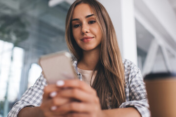 European girl using mobile phone at desk