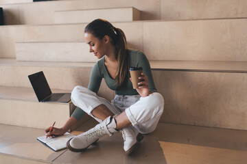 European girl writing in notebook during study