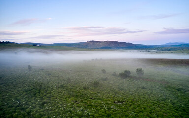 Fog over green field in highlands