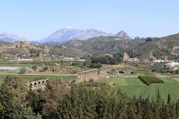 Fototapeta na wymiar beautiful landscape with mountains, sky and Roman aqueduct of ancient city Aspendos in Turkey