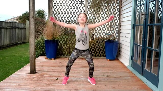 Young happy girl exercising on porch at home