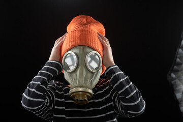 Portrait of a boy in a gas mask on a dark background