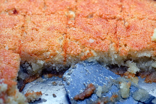 Selective focus of a tray of basbosa cut in pieces with honey sugary syrup on it, Basbusa is a middle eastern dessert that is usually baked in Ramadan month, Arabian sweet cuisine