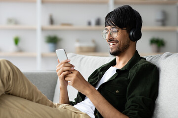 Handsome indian guy watching video on smartphone