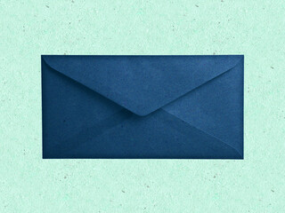 Navy blue envelope isolated on green background. Kraft paper with subtle fibers. Vintage style. 