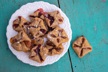 Czech cheesecake pastry folded cubes baskets biscuits wrapped filled with red jam on rustic scratched vintage background