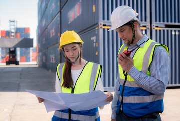 Man and women caucasian team worker standing and wearing safety work equipment clothes is Working and checking containers layout in blueprint at a warehouse shipment, cargo, import, export  industry.