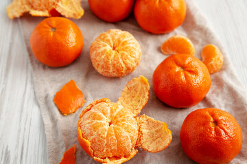 Raw Organic Mandarin Oranges on a white wooden background, side view. Close-up.