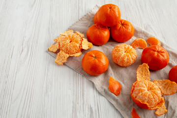 Raw Organic Mandarin Oranges on a white wooden background, side view. Copy space.