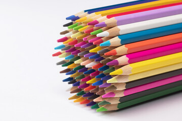 Multi-colored pencils on white paper. Drawing materials. Shallow depth of field