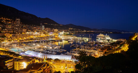 Aerial view of port Hercules in Monaco - Monte-Carlo at dusk, a lot of yachts and boats are moored in marina, cityscape with night illumination, magic reflection on water, mountain, mediterranean sea - obrazy, fototapety, plakaty
