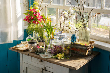 Vintage cupboard on veranda on sunny spring day decorated with flowers, Easter retro decor and...