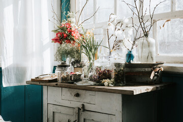 Vintage cupboard on veranda on sunny spring day decorated with flowers, Easter retro decor and willow branches, Easter family celebration