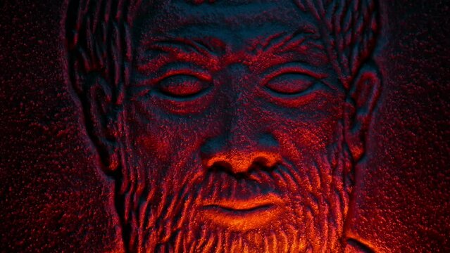 Man's Face Stone Carving Lit Up In Fire Glow