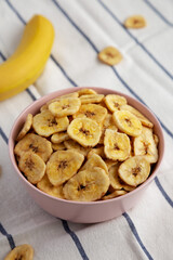 Homemade Banana Chips in a Pink Bowl, top view. Flat lay, overhead, from above.