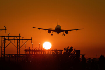Fototapeta na wymiar Airplane landing with the sun nearby