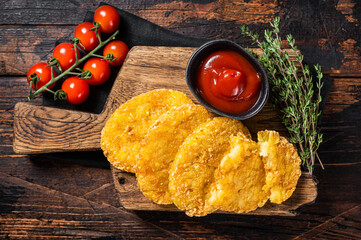 Hash brown potato, Potato Patties on a wooden board with ketchup. Wooden background. Top view
