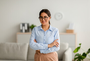 Professional psychotherapy. Portrait of young successful arab female psychologist posing with folded arms in office - obrazy, fototapety, plakaty