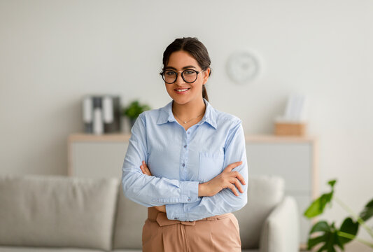 Professional psychotherapy. Portrait of young successful arab female psychologist posing with folded arms in office