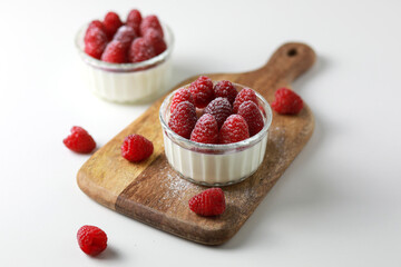 Italian dessert panna cotta with raspberries on white background.