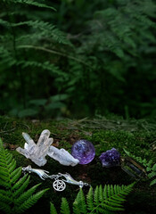 quartz minerals, witch wiccan amulet with pentagram on moss, forest dark natural background....