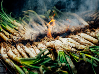 Cuisson des calçots au feu pour une Calçotada fête traditionnelle de Catalogne