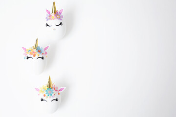 Easter eggs decorated with unicorn stickers on a white background. Copy space. Top view. Background for Easter.