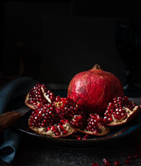 Pomegranate on a dark table background. Red, ripe, sweet and delicious