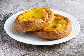 Sweet. White porcelain plate with two ensaimadas covered with burnt cream, typical of Spain.