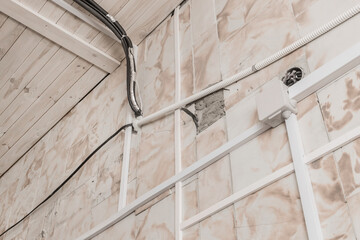 Old cable cord wiring insulation system on the wall near the ceiling