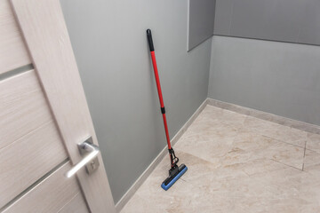 Mop stands against the wall and floor cleaning of production facilities. Household chores and hygiene of sanitary facilities