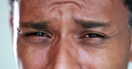 Tearful sad african american person eyes close-up squinting crying