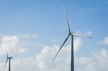 Windmills during bright summer day with blue sky, clean and renewable energy concept. - 484746935