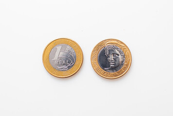 Real, a moeda brasileira. Duas moedas de 1 Real isoladas em fundo branco mostrando a frente e o...