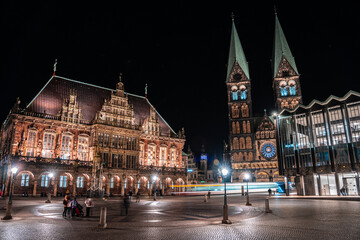 Bremen cathedral Bremer Dom and town hall Bremer Rathaus with Roland in front. Night with motion on central square of northern germen city. Illuminated historical buildings. - obrazy, fototapety, plakaty