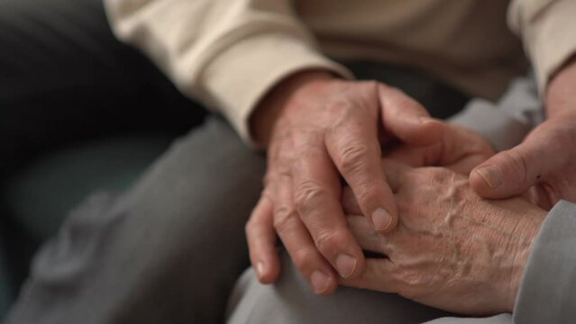 Real feelings. Close up of hands of nice elderly people being held together. Senior old couple husband and wife holding hands close up view, mature elderly family