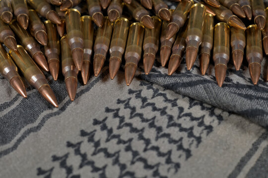 .308 caliber ammunition on a green-gray fabric background (keffiyeh)