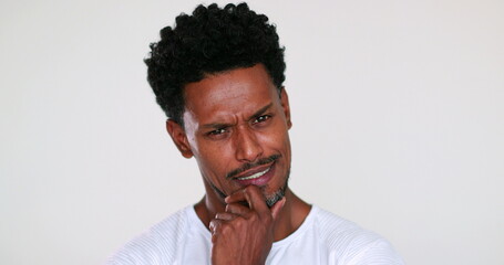 Pensive African American man portrait looking to camera deciding. Thoughtful black guy pondering decision